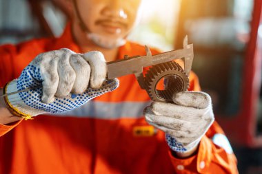 Teknisyenlerin eli kapalı: Vernier Caliper ve buldozer çıkıntısını denetim ve bakım ağır makineleri, Endüstriyel Tema.