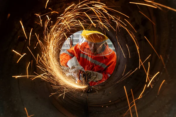 工业工人用许多锋利火花切割金属管的电动砂轮磨削 — 图库照片