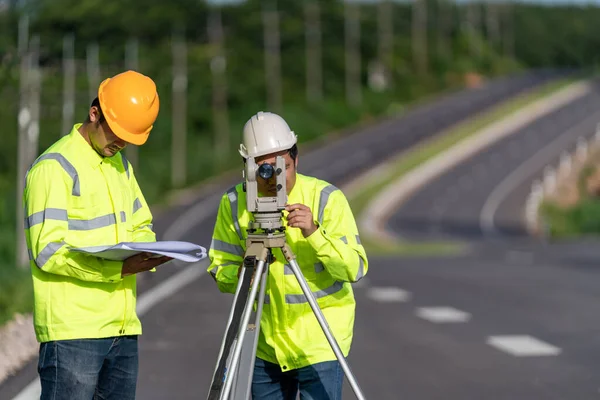 Two surveyor engineers with equipment on road construction site, Civil Engineers, Surveyor equipment.