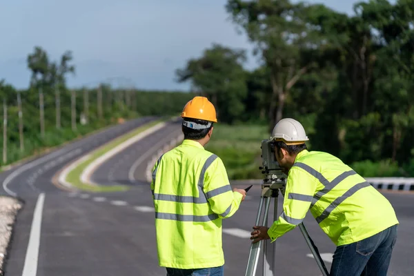 道路建設現場 土木技術者 測量機器を備えた測量技術者のチームワーク — ストック写真