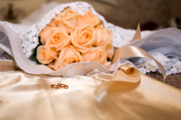 Bridal bouquet on the dress and rings — Stock Photo, Image