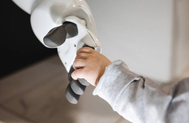 Kız robota elini uzattı. Bir robotla çocuk arasındaki arkadaşlık kavramı