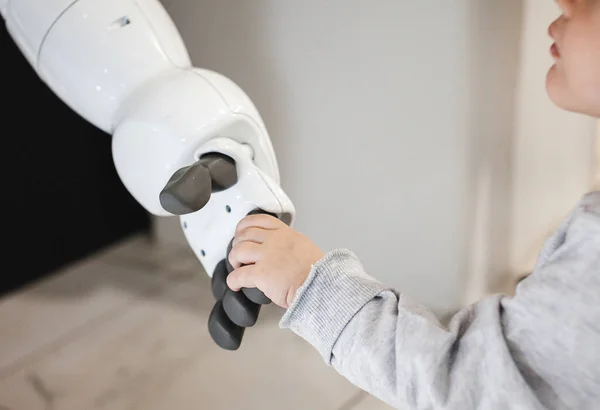 La fille tend la main au robot. Concept d'amitié entre un robot et un enfant Photos De Stock Libres De Droits