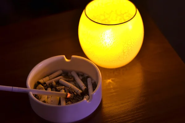 Cigarette in ashtray in dark — Stock Photo, Image