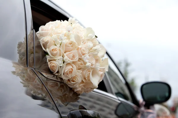 Car and brides bouquet in a car window — Stock Photo, Image