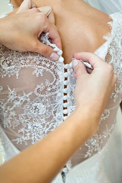 Abotoando o vestido na noiva, detalhes de belo vestido de noiva de renda — Fotografia de Stock