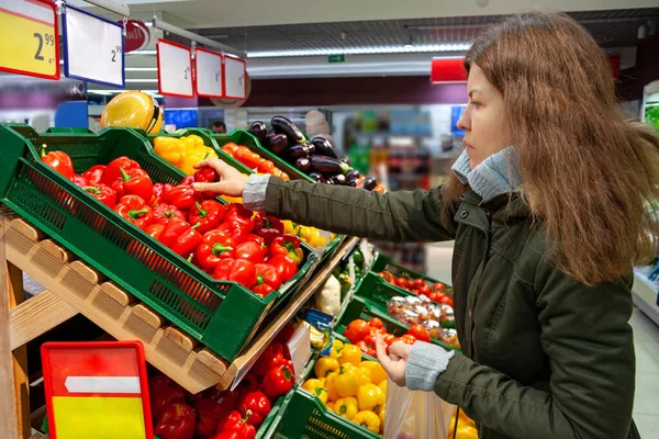 Mujer Sosteniendo Pimiento Rojo Examinándolo Con Cuidado Mientras Compra Supermercado —  Fotos de Stock