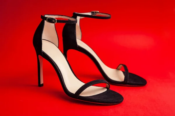 Sexy Vrouwen Zwarte Sandalen Met Hoge Hakken Een Rode Achtergrond — Stockfoto