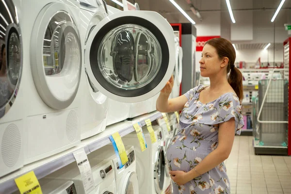 Беременная Женщина Магазине Выбирает Стиральную Машину — стоковое фото