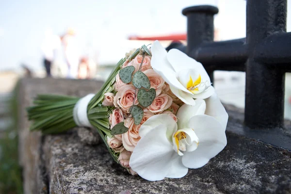 Boeket verse bloemen in de buurt van de Bolder. Wedding bouquet van rozen en orchideeën. — Stockfoto