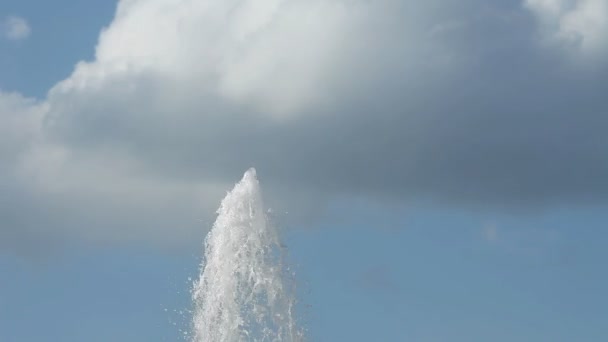 Fuente de agua. El agua se eleva hacia arriba contra el cielo azul con nubes . — Vídeos de Stock