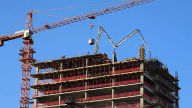 yüksek katlı bina inşaat altında vinç ve beton pompası.