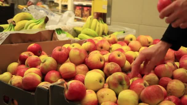 A mão da mulher a apanhar fruta no supermercado. Escolhendo maçãs no supermercado . — Vídeo de Stock