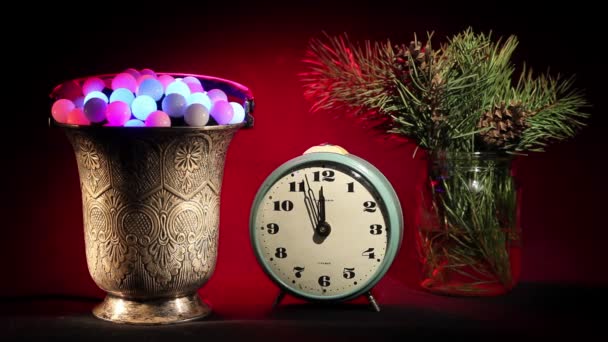 Yeni yıl. Vintage saat, yanıp sönen ışıklar ve Noel ağacı ile gümüş vazo şubeleri. — Stok video