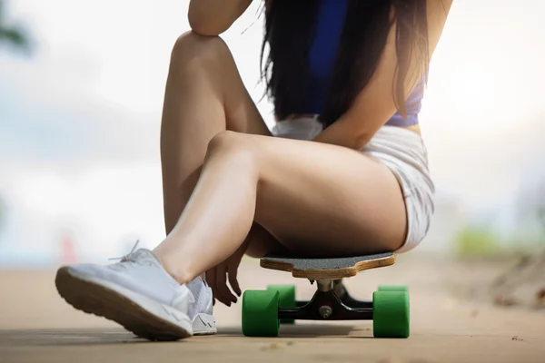 Girl sitting on the skateboard — Stock Photo, Image