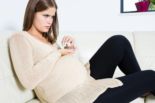 Worried pregnant woman taking pills — Stock Photo, Image