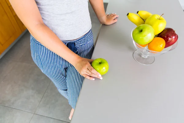 Donna irriconoscibile in cucina con frutta — Foto Stock