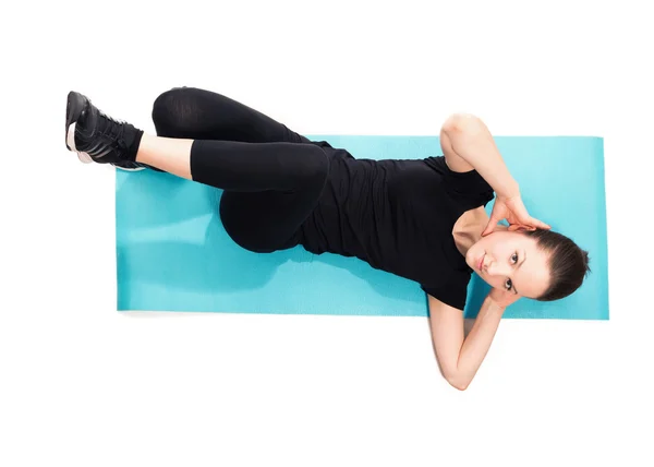 Vältränad kvinna gör crunches på träningsmatta — Stockfoto