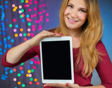 Genç sevimli kadın gösteren dijital tablet ile boş perde