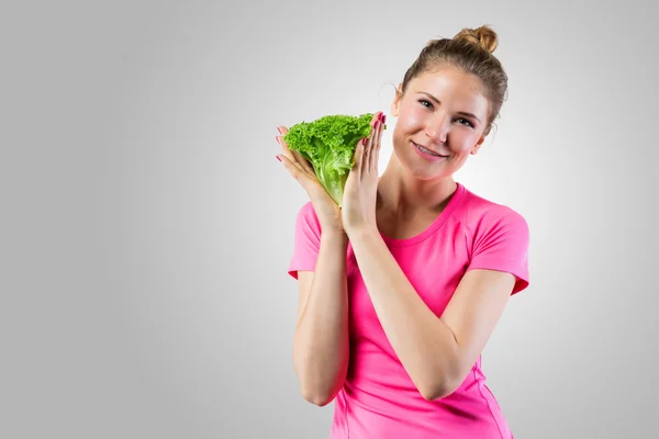 Улыбающаяся женщина с зеленым салатом — стоковое фото