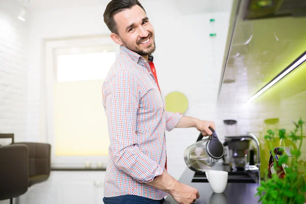 Hombre alegre preparando té en el sol de la mañana — Foto de Stock