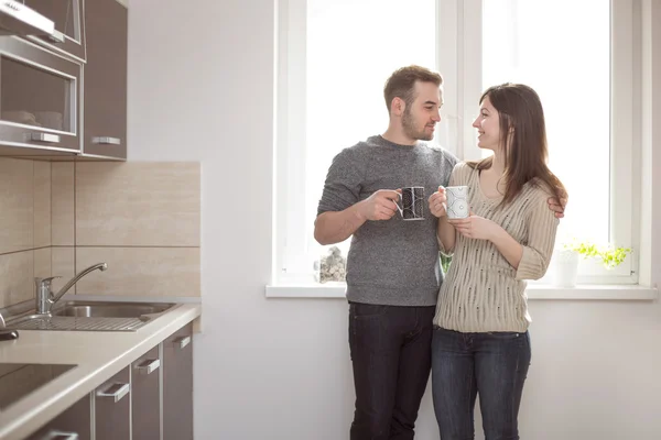 Молодая пара пьет кофе на кухне — стоковое фото