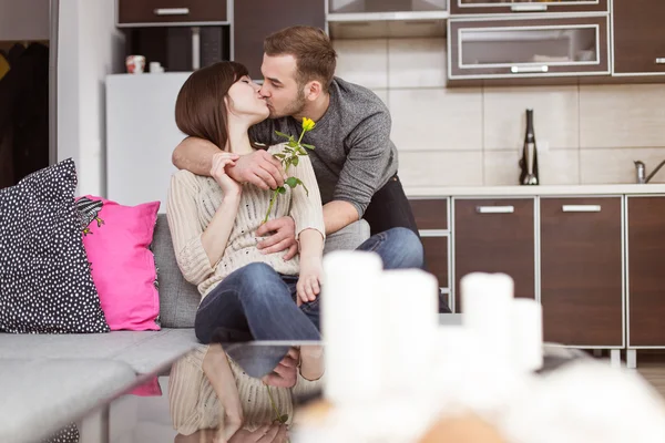 Pareja joven besándose en sofá — Foto de Stock