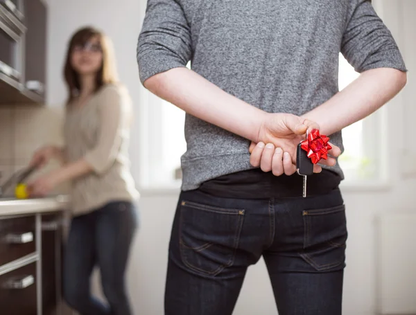 Man houden cadeau autosleutels achter zijn rug om te geven van zijn vrouw — Stockfoto