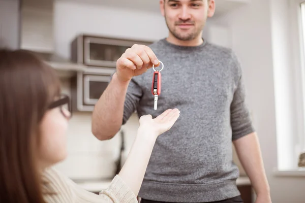 Man die een vrouw auto sleutels geeft — Stockfoto