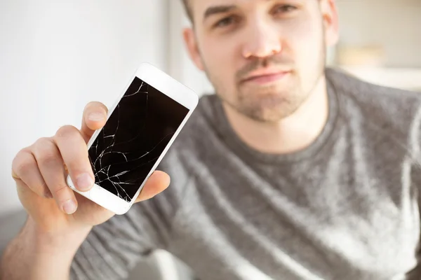 Trauriger Mann zeigt abgestürztes Handy mit Touchscreen — Stockfoto