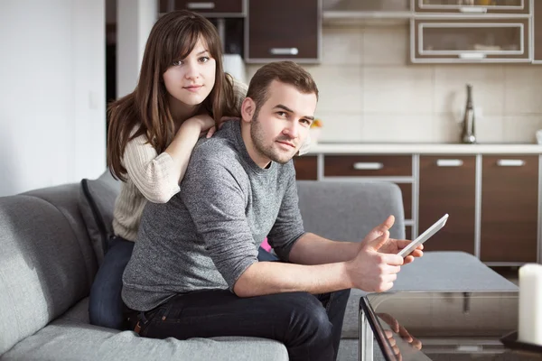 Young man and woman surfing the net on digital tablet — Stock Photo, Image