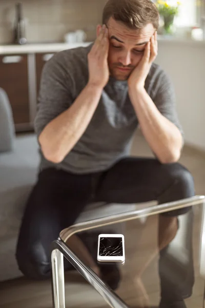 Worried man looking at broken smart phone — Stock Photo, Image