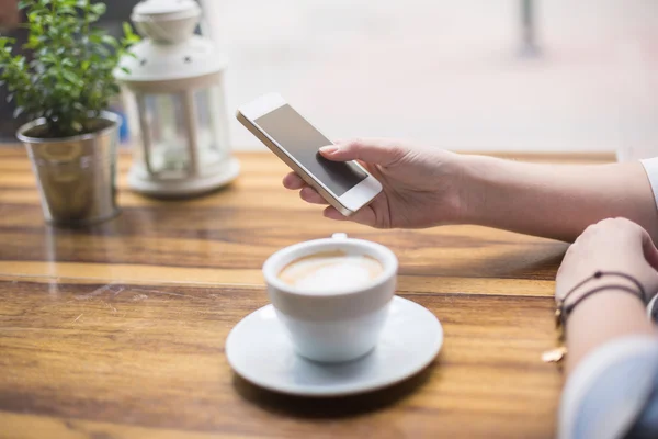 SMS op slimme telefoon terwijl het hebben van koffie — Stockfoto