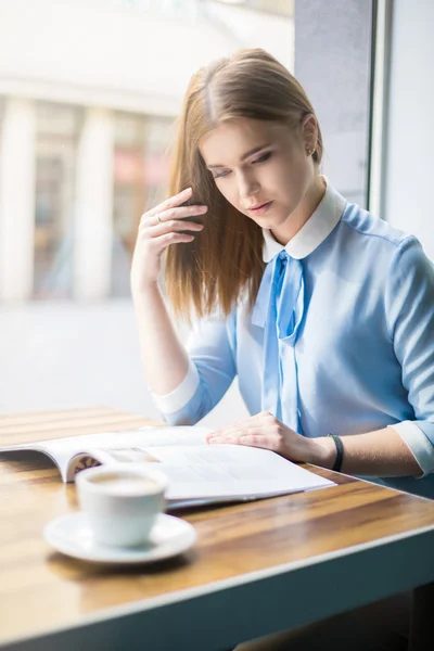 Mujer joven leyendo revista en la cafetería — Foto de Stock