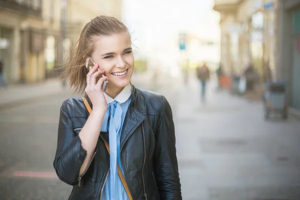 Na telefonu v městě na sunset — Stock fotografie