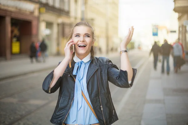 Mujer feliz recibiendo buenas noticias por teléfono en el centro de la ciudad —  Fotos de Stock