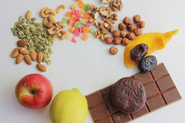 stock image proper nutrition, fruits apples and lemons and dried fruits dates and nuts with seeds or sweets harmful to health are chocolate, cookies and cakes. proper nutrition instead of sweets, dried fruits