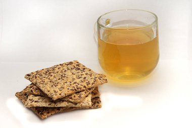 Mısır gevrekli kraker ve beyaz arka planda bir bardak yeşil çay