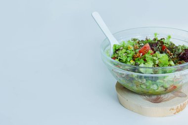 Yazı lezzetli ve sağlıklı. Büyük bir cam tabakta taze sebze salatası resmi var.