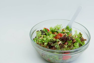 Büyük cam tabakta taze sebzeli yaz salatası.
