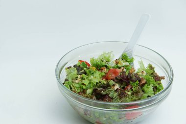 Büyük cam tabakta taze sebzeli yaz salatası.