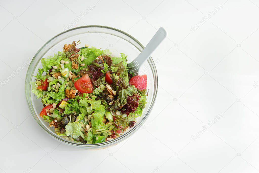 the inscription tasty and healthy with the image of a salad of fresh vegetables in a large glass plate