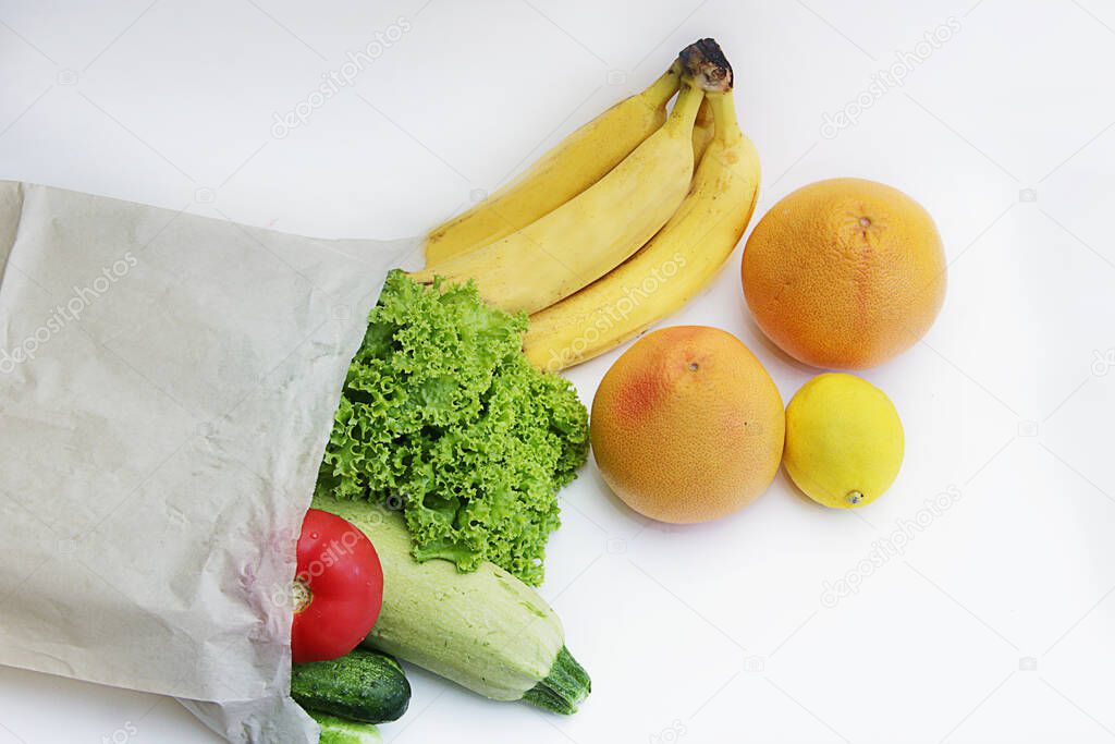 online shopping in online stores during isolation and to save time. Paper bag filled with fruit and vegetables bananas, grapefruits, lettuce, tomatoes, cucumbers