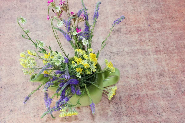 lavender flowers in a teapot on a wooden background