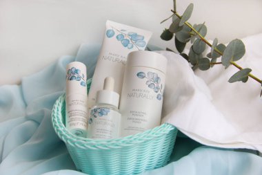 Mary Kay şirketinin beyaz havluyla huş ağacından sepetin içindeki mavi kumaş üzerindeki yüz bakımı kremleri 15.03.2021 numaralı kremdir.