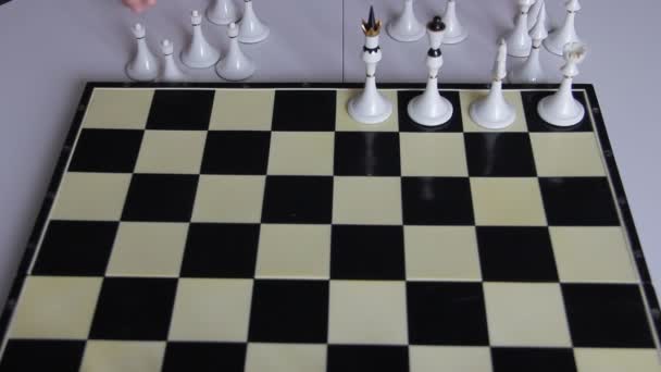 Un enfant place un jeu d'échecs blanc sur un échiquier pour jouer — Video