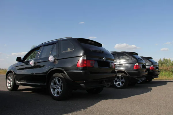 GOMEL, República de Bielorrusia, 29 de agosto de 2015: cortejo de bodas de cinco coches idénticos decorados en negro —  Fotos de Stock