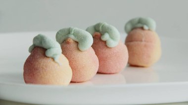 Beyaz arka planda cam bir vazoda şekerleme. Vazodaki farklı şekillerde şekerlemeler. Şekerler.