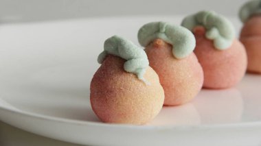 Beyaz arka planda cam bir vazoda şekerleme. Vazodaki farklı şekillerde şekerlemeler. Şekerler.