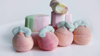 Beyaz arka planda cam bir vazoda şekerleme. Vazodaki farklı şekillerde şekerlemeler. Şekerler.